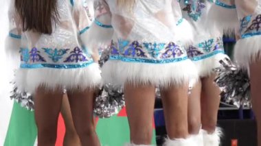 Kısa kostümlü kadın takımı hokey maçında dans ediyor.