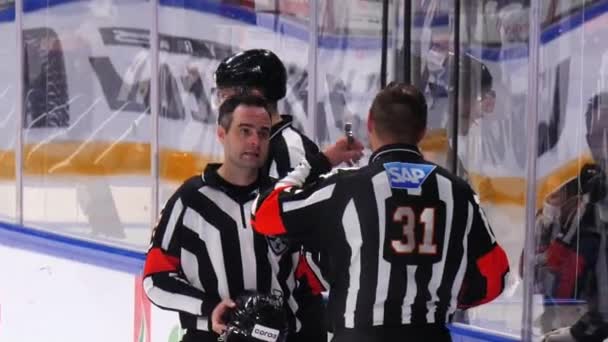 Geschoolde hockeyjuryleden in gestreept uniform praten op de ijsbaan — Stockvideo
