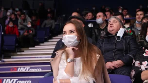 Happy young woman with medical mask watches hockey game — Stock Video
