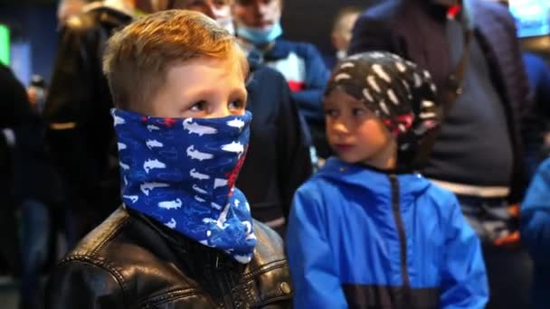 Liten pojke med bandanna i ansiktet väntar på hockeymatch — Stockvideo