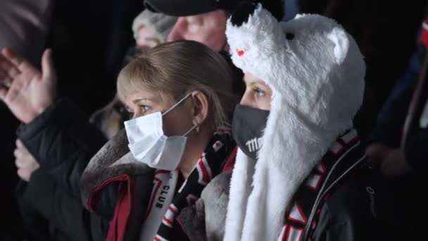 Upprörda kvinnor supportrar med masker titta på hockey match — Stockvideo