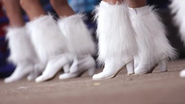 Kabarık çizmeli ponpon kız takımı hokey maçında dans ediyor.