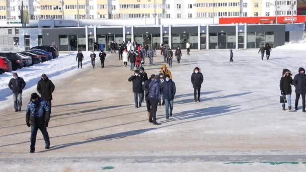 As pessoas caminham ao longo da praça nevada perto da estação de metrô — Vídeo de Stock