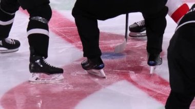 Hakem hokey takımları arasındaki maça başlamak için puck atıyor.