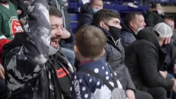 Happy man with jumping little son celebrates goal at hockey — Stock Video