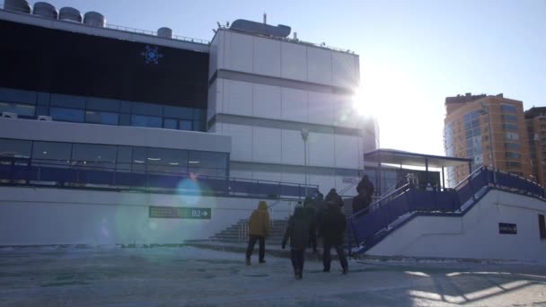 Pedoni a piedi per l'edificio dello stadio con scale in inverno — Video Stock