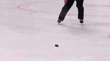 Siyah üniformalı hokey hakemi buz arenasından diski aldı