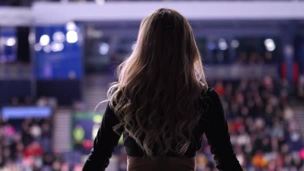 Блондинка танцует болельщицы, чтобы развлечь зрителей на хоккейном матче — стоковое видео