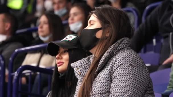 Mulheres positivas fãs de esportes com máscaras assistir jogo de hóquei — Vídeo de Stock