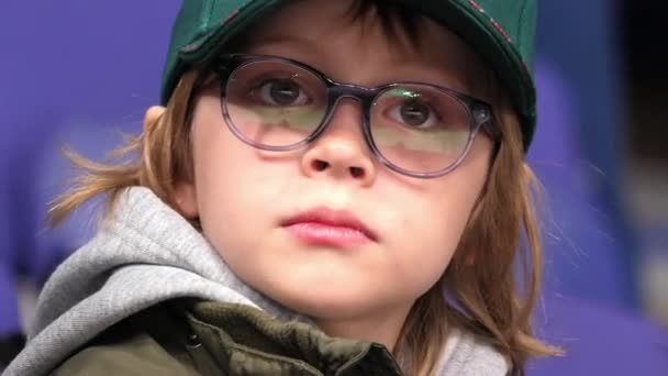 可爱的小男孩戴着眼镜和绿帽看曲棍球 — 图库视频影像