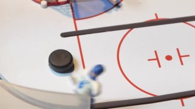 Oyuncak hokey oyuncusu figürleri buz pistinde puck 'ı tekmeliyor