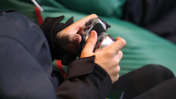 Teenager hraje videohru s joystickem na fazolovém křesle — Stock video