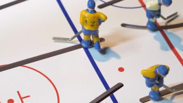 Tiny hockey players figures fight for puck on toy ice arena — Stock Video