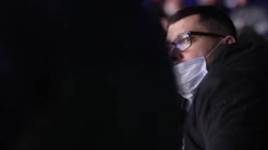 Genç adam ve meraklı küçük oğlan birlikte hokey maçı izliyorlar.