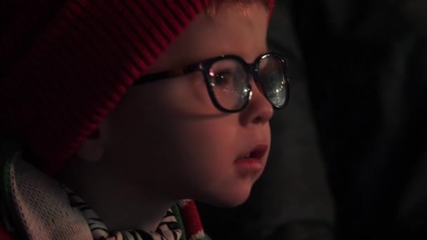 Amazed preschooler boy with glasses watches hockey game — Stock Video