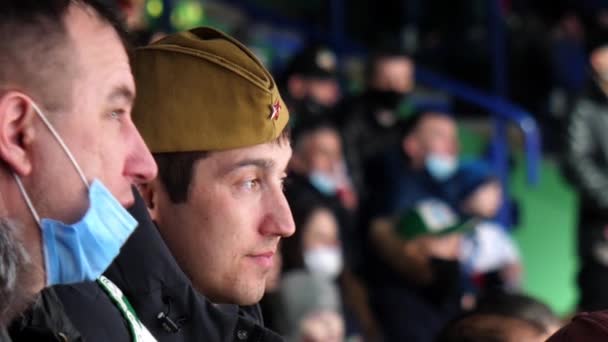 Man talks to friend with soviet military hat at hockey — ストック動画