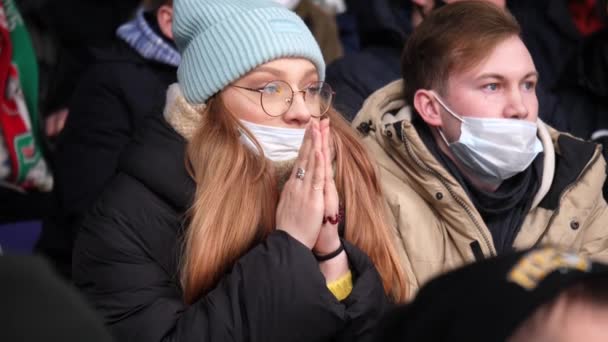 Mujer con novio mira partido de hockey sentado en tribuna — Vídeos de Stock