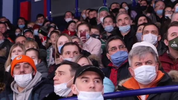 Gli spettatori con maschere mediche guardano la partita di hockey allo stadio — Video Stock