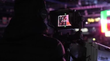 Spor hayranlarını çeken kameraman silueti.