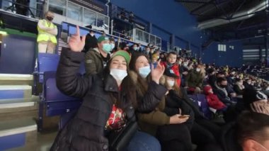 Hokey taraftarları maç izler ve ziyaretçiler stadyum boyunca yürür