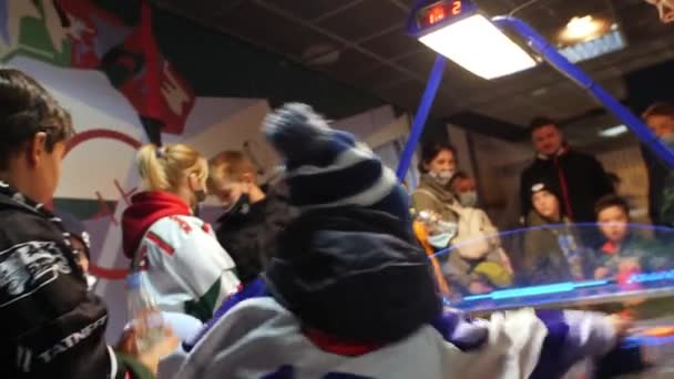Kleine Jungen in warmen Klamotten spielen Airhockey und Unterstützer — Stockvideo