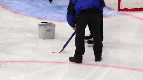 Arbetare tar bort smuts från isen med skrapa för hockeymatch — Stockvideo