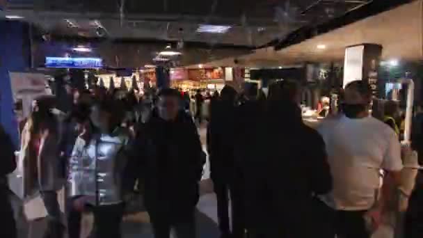 Любители хоккея прогуливаются по коридору стадиона с магазинами и кафе — стоковое видео
