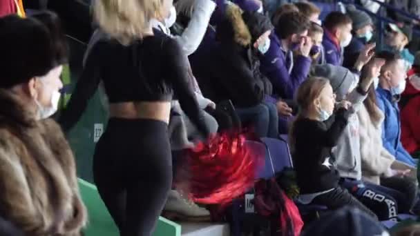 Woman cheerleader in tracksuit shakes pompoms on tribune — Stock Video