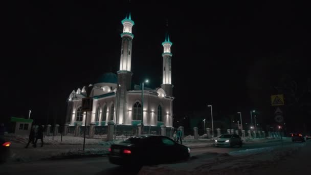 Чудова мечеть з мінаретами і куполом на засніженій нічній вулиці — стокове відео