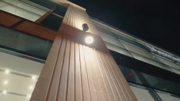 Lámpara de araña con lámpara led om fachada de tienda en la noche de invierno — Vídeo de stock