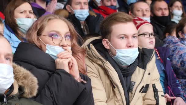 Ładna kobieta w masce i przyjaciel oglądać hokej na stadionie — Wideo stockowe