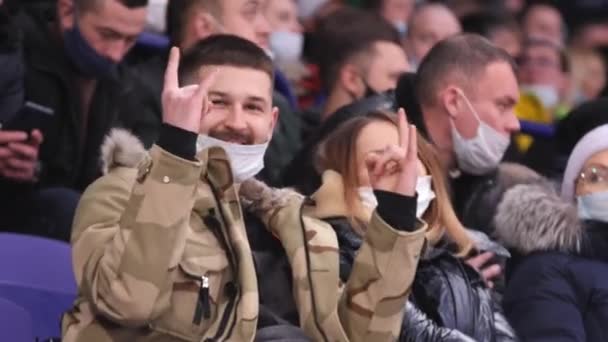 Uomo baffuto con maschera medica mostra corna guardando hockey — Video Stock