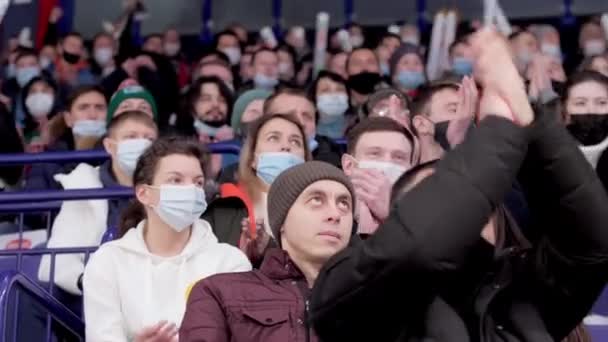 Hombre con máscara aplaude las manos y niño viendo partido de hockey — Vídeos de Stock