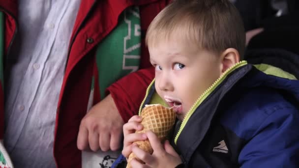 Χαριτωμένο αγοράκι τρώει παγωτό σε tribune στο παιχνίδι χόκεϊ — Αρχείο Βίντεο