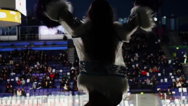 Silhouette of slim cheerleader woman dancing at hockey game — Stock Video