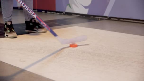 Muž návštěvník kopne puk s tyčí hrát podlahy hokej — Stock video