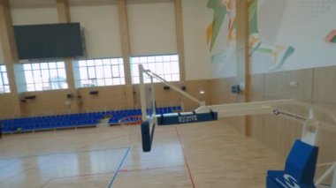 Genç çocuk takımları arenada basketbol oynuyorlar.