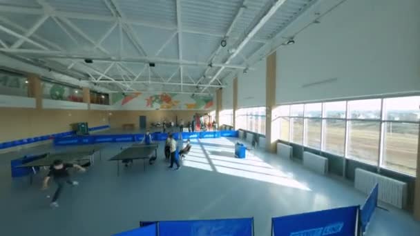 Entrenan deportistas en gimnasio con máquinas y mesas de ping-pong — Vídeo de stock
