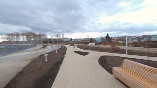 Estrada vazia e canal no parque da cidade jovem sob nuvens pesadas — Vídeo de Stock