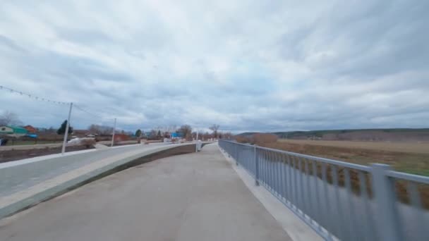 Sentiero asfaltato con ringhiera oltre stretto canale nel parco — Video Stock