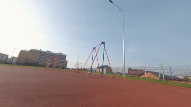 Verschiedene Turnstangen auf leerem Sportplatz in Schulnähe — Stockvideo