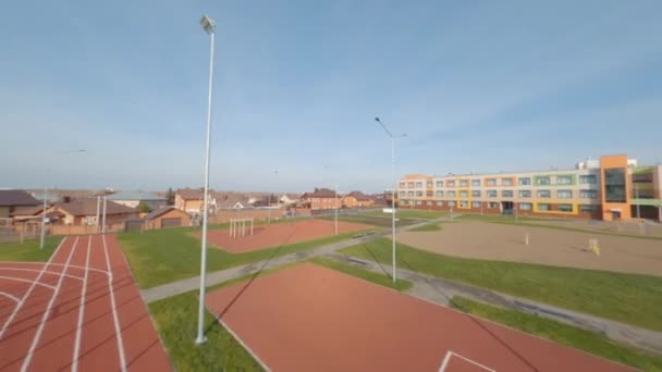 Sportveld met trainers en hardloopbanen in de buurt van school — Stockvideo