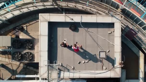 Hombres lanzan drones de pie en la azotea de rascacielos redondos — Vídeo de stock