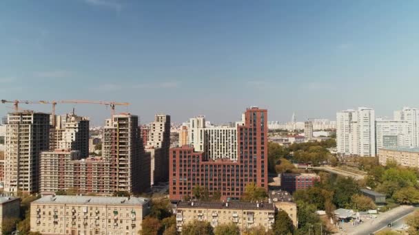 Lägenhet byggnader block och kranar i staden under blå himmel — Stockvideo