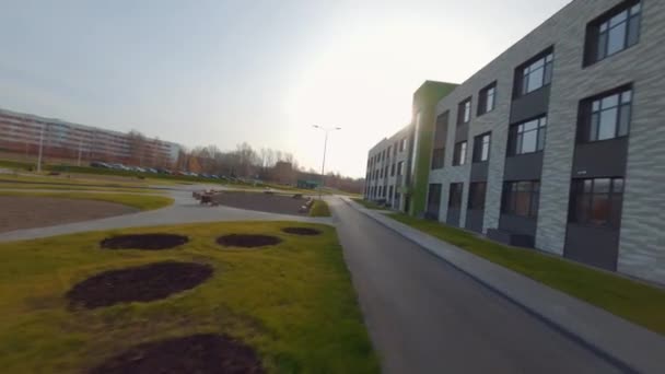 Park met weelderige gazons in de buurt van kantoorgebouw onder heldere hemel — Stockvideo