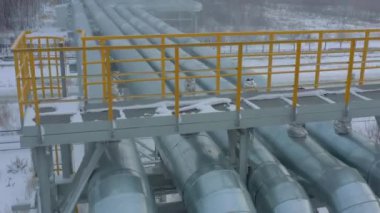 Kışın gaz ve petrol rafinerisindeki yol üzerindeki boru hatları.