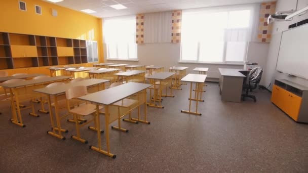 Sala lekcyjna z biurkami dla młodszych nauczycieli w miejscu pracy — Wideo stockowe