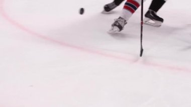 Hokey oyuncuları yarışma sırasında arenada puck için dövüşürler.