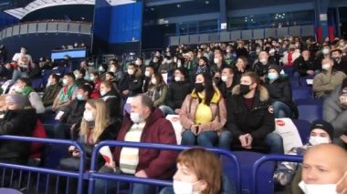 Maskeli izleyiciler stadyumdaki hokey takımlarının maçlarını izliyor.