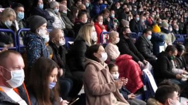 Maskeli spor taraftarları yerel hokey takımını destekliyor